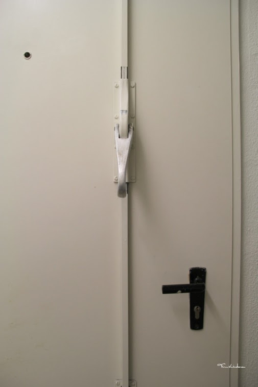 Weiße Gefängnistür mit Schloss und Riegel