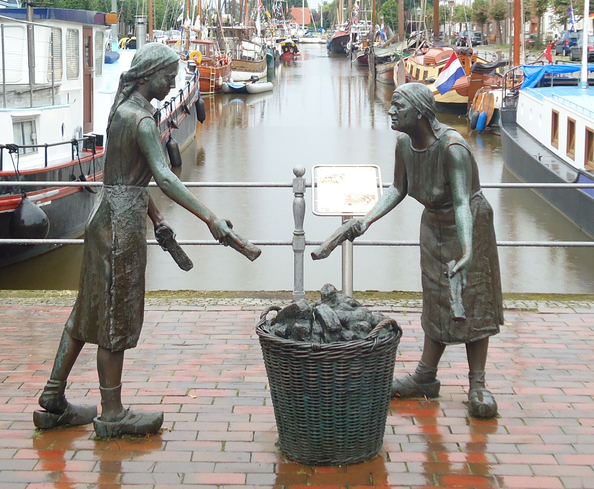 Foto: Bronzeskulptur. Darstellung zweier arbeitenden Torfladenarbeiterinnen des 19. Jahrhunderts.